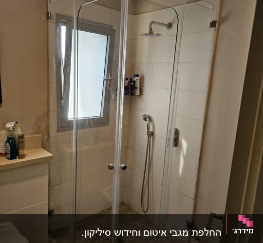 מקלחון זכוכית עם ראש מקלחת ומדף מוצרים